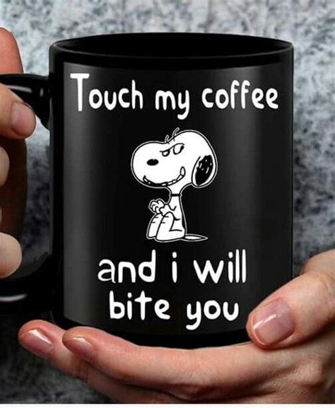 A Person Holding A Black Coffee Mug With A Cartoon Character On It That