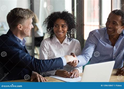 Diverse Businessmen Finish Successful Negotiations With Handshake Stock