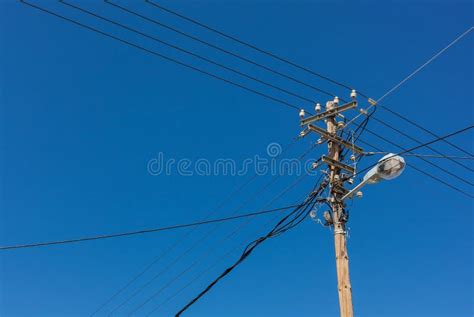 Telephone Lamp Pole With Electrical Wires Against Blue Sky Stock Photo