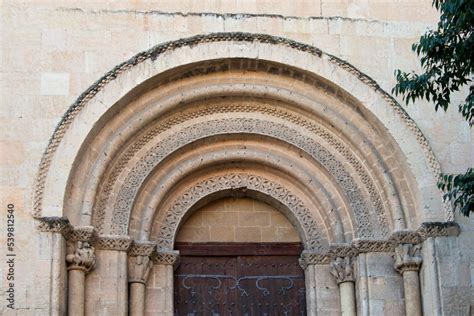 Decorated Romanesque Flared Arch And Capitals With Sculptures In The