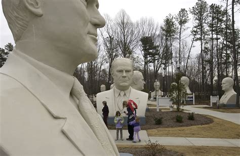 Ghostly sculptures of presidential heads are sitting in a field in ...