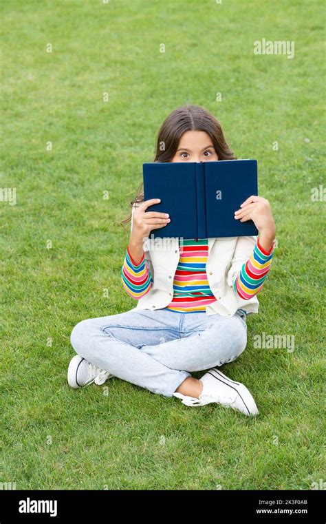 Teen Girl Behind Book Sitting On Grass Reading Book Reader Girl Read