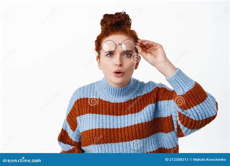 Portrait Of Confused Redhead Girl Takes Off Her Glasses And Squinting