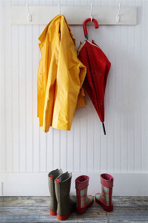 "Rain Gear With Boots Hanging On Coat Hooks" by Stocksy Contributor "Sandra Cunningham" - Stocksy