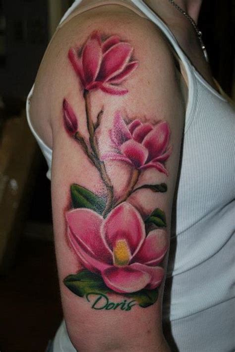 Wonderful Colorful Magnolia Flowers With Namw Quote Tattoo On Upper Arm