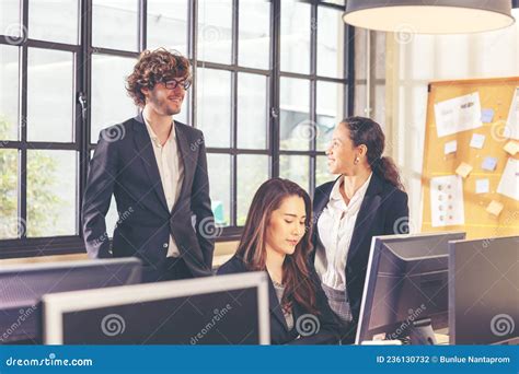 Colleagues In A Boardroom Discussion Seated At A Table Together