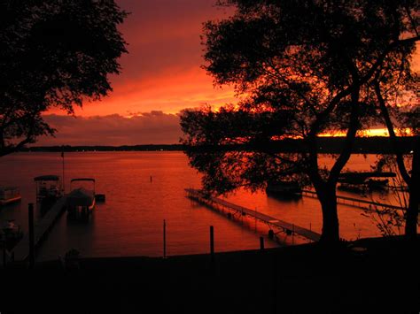 The Sun Is Setting Over Some Water And Boats Are Parked On The Dock In