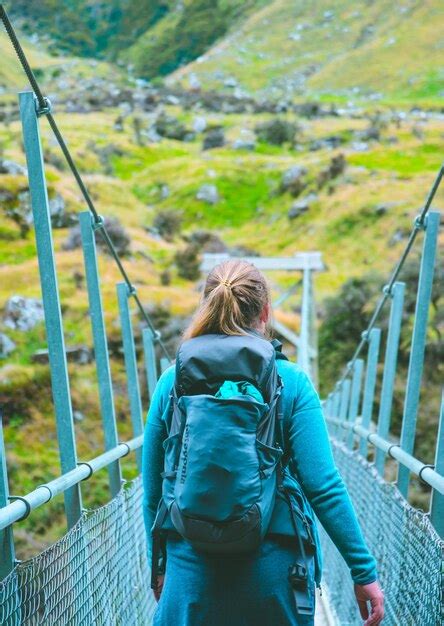 Premium Photo Rear View Of Female Hiker Walking On Footbridge Against