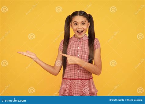 Surprised Teen Girl Pointing Finger On Yellow Background Copy Space