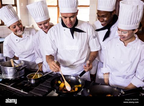 Group Of Chefs Preparing Food In Kitchen Stock Photo Alamy