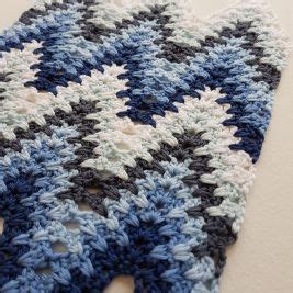 A Blue And White Crocheted Dishcloth Is Laying On The Floor Next To A Wall