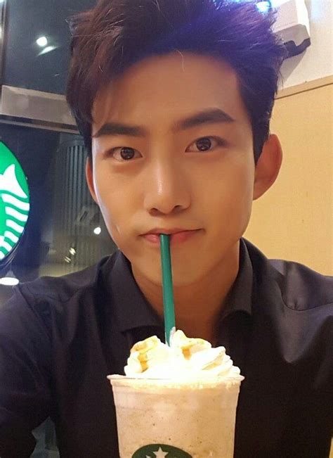 A Man Holding A Starbucks Drink With A Straw In His Mouth