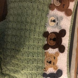 There Is A Crocheted Blanket With Teddy Bears On It