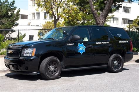 a police vehicle parked on the side of the road near a fenced in area