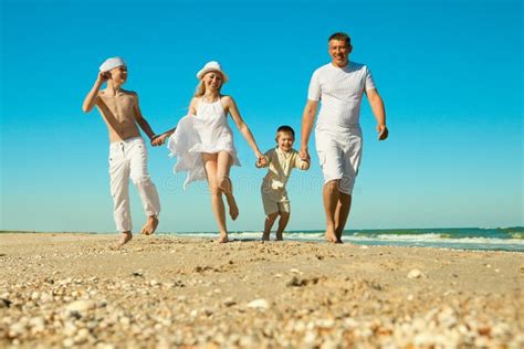 Familia Que Recorre A Lo Largo De La Playa Foto De Archivo Imagen De