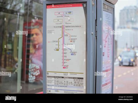 TFL Bus route sign indicator at bus stop (Green Park Station), with bus passenger in background ...