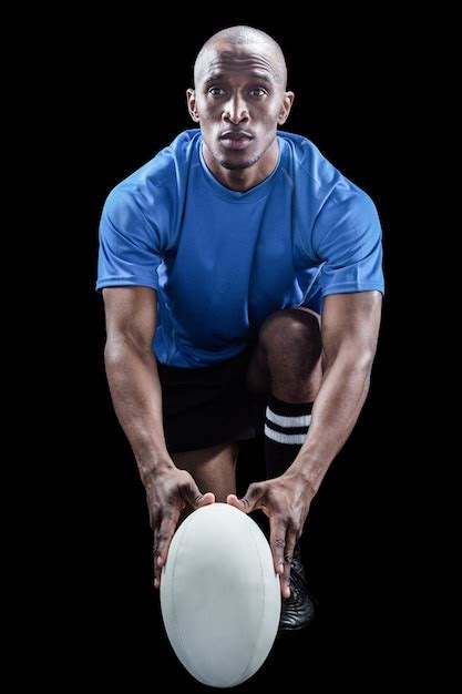 Premium Photo Portrait Of Rugby Player Holding Ball While Kneeling