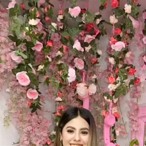 A Woman Standing In Front Of Pink Flowers