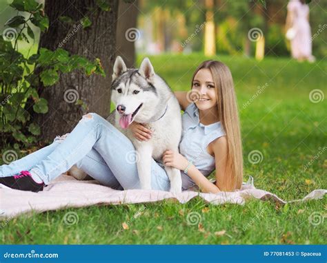 Attractive Young Woman Hugs Funny Siberian Husky Dog Stock Image