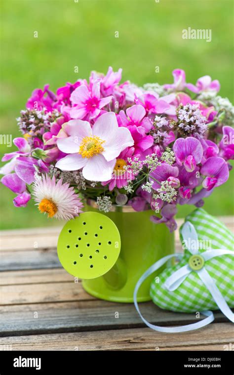 Pink Garden Flowers In A Small Watering Can Stock Photo Alamy