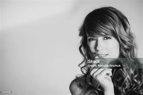 Portrait Of A 36 Year Old Woman With Curly Hair And Brown Slanting Eyes