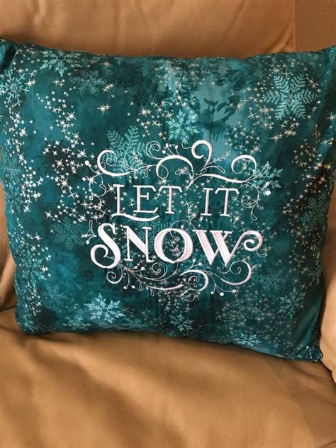 A Green Pillow That Says Let It Snow