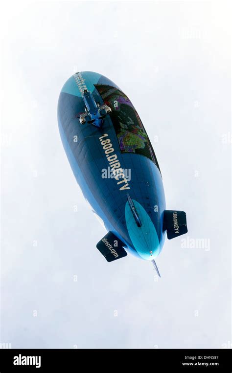 Blue and turquoise hot air blimp navigates above the football stadium advertising DirecTV in ...