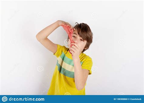 Young Boy Showing A Red Slime Looks Like Gunk Between His Hands Stock