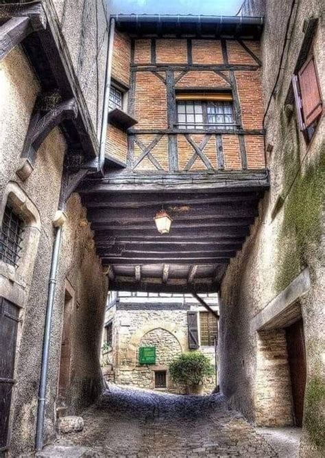 An Alley Way With Stone Buildings And Brick Walls On Both Sides