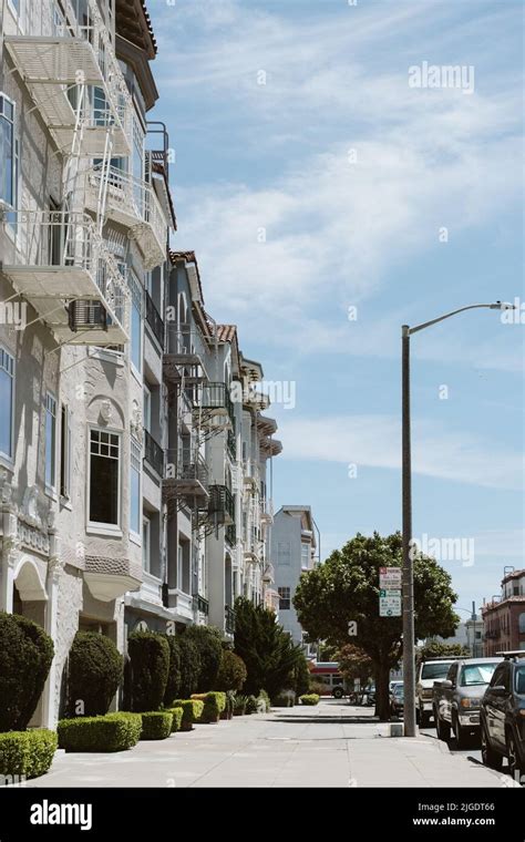 A Vertical Shot Of Empty Street And Facade Of White Buildings Parked