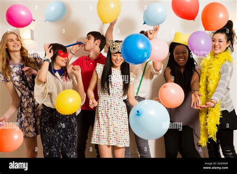 Friends at a party with balloons, studio shot Stock Photo - Alamy