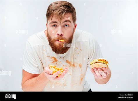 Funny hungry bearded man eating junk food isolated on white background ...