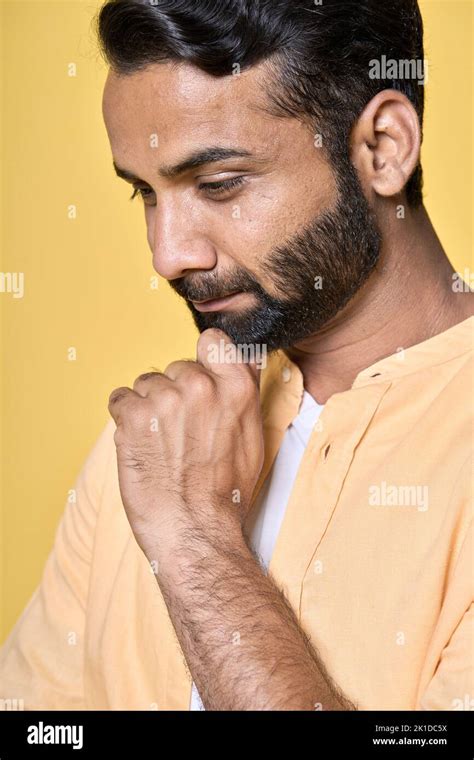 Smiling Thoughtful Indian Man Thinking Isolated On Yellow Vertical