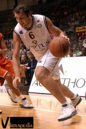 Two Men Playing Basketball On A Court With People Watching From The