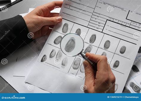 Female Criminalist Exploring Fingerprints With Magnifier Stock Image