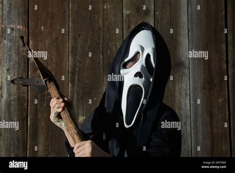 Man in scary "scream" mask holds axe. Mask of grim reaper. Carnival ...