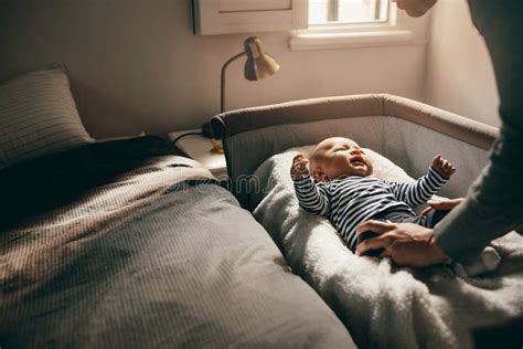 Woman Putting Her Baby In A Bedside Crib Stock Image Image Of Sleep