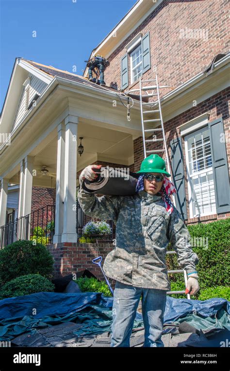 Roofing Contractors Replacing Damaged Roofs After A Hail Storm Stock