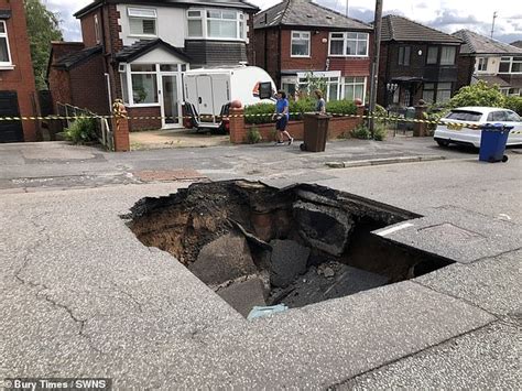 Huge Ft Wide Sinkhole Opens Up In Middle Of Residential Street