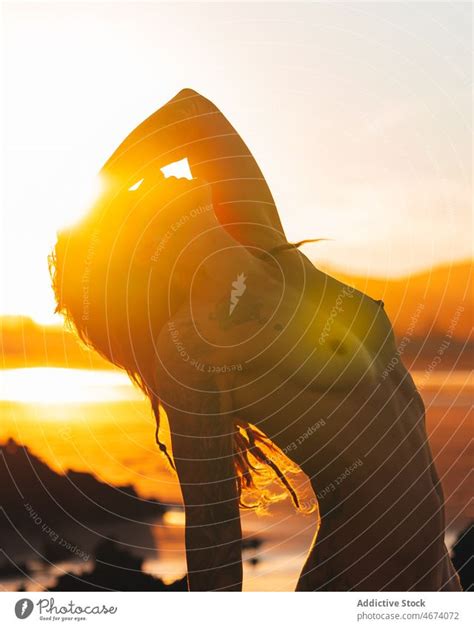 Faceless Naked Woman Standing In Sea At Sunset Time A Royalty Free