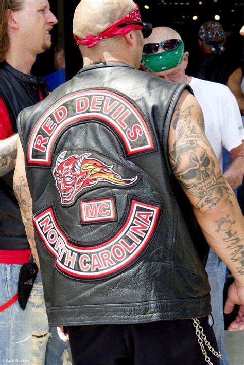 Two Men Wearing Leather Vests And Bandanas Are Talking To Each Other In