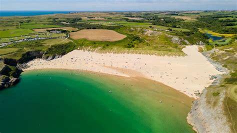 Aerial View Of A Large Busy Sandy Beach And Rocky Coastline In West