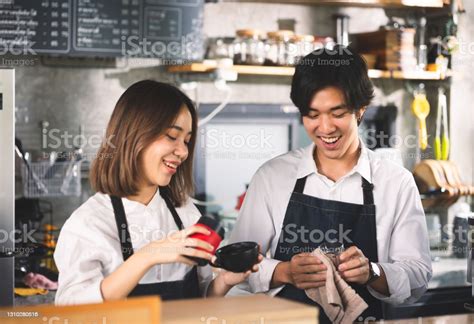 Two Asian Coffee Waitress Making Cup Of Hot Coffee Latte In Coffee Shop