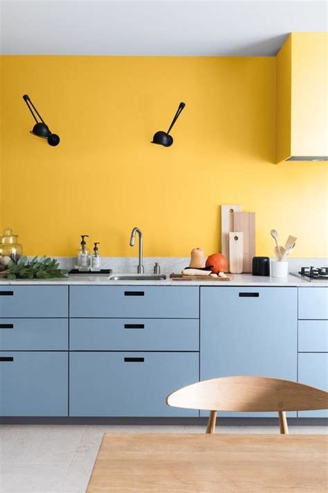 A Chic Modern Kitchen With A Yellow Accent Wall And Light Blue Sleek