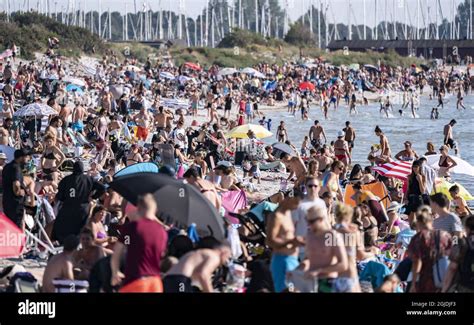 People enjoying the sun and warm weather on a crowded beach in Lomma