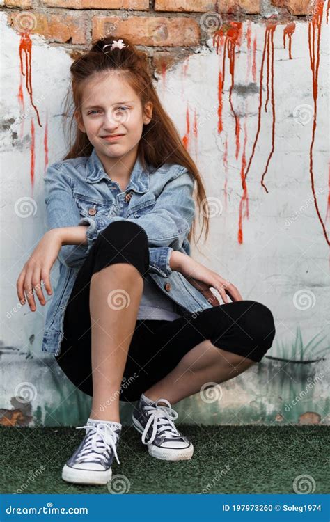 Portrait Of A Beautiful Teenage Girl Posing Against A Brick Wall Stock