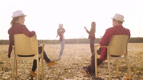 Los Padres Felices Descansan Viendo a Los Niños Jugar Al Balón Concepto