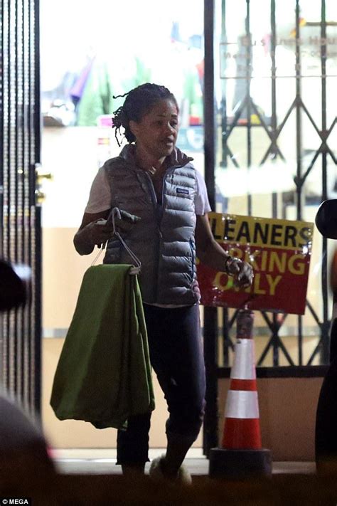 A Woman Walking Down The Street Carrying Shopping Bags