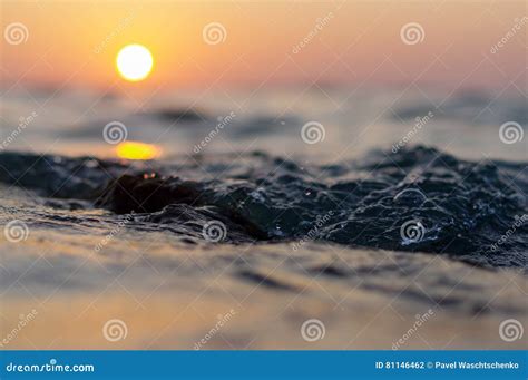 Sea Wave Close Up At Sunset Time With Red And Orange Sun Reflection On