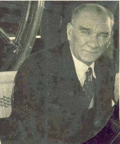 An Old Black And White Photo Of A Man In A Suit Sitting At A Table